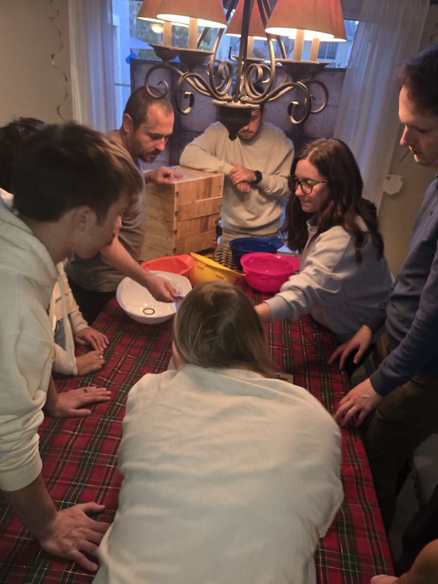 Players solving puzzles around a family dining room table